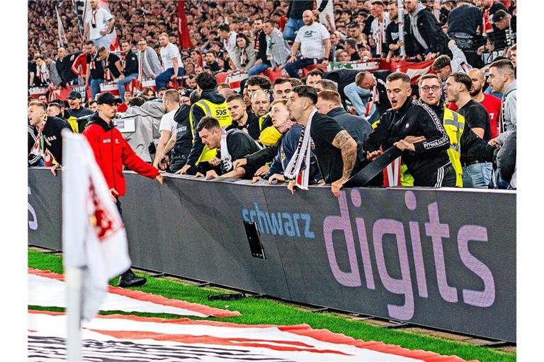Einige VfB-Fans dringen gegen den BVB in den Innenraum ein.