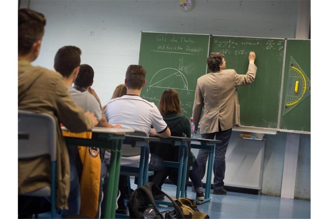 Ein Lehrer schreibt während des Matheunterrichts an die Tafel. Foto: Marijan Murat