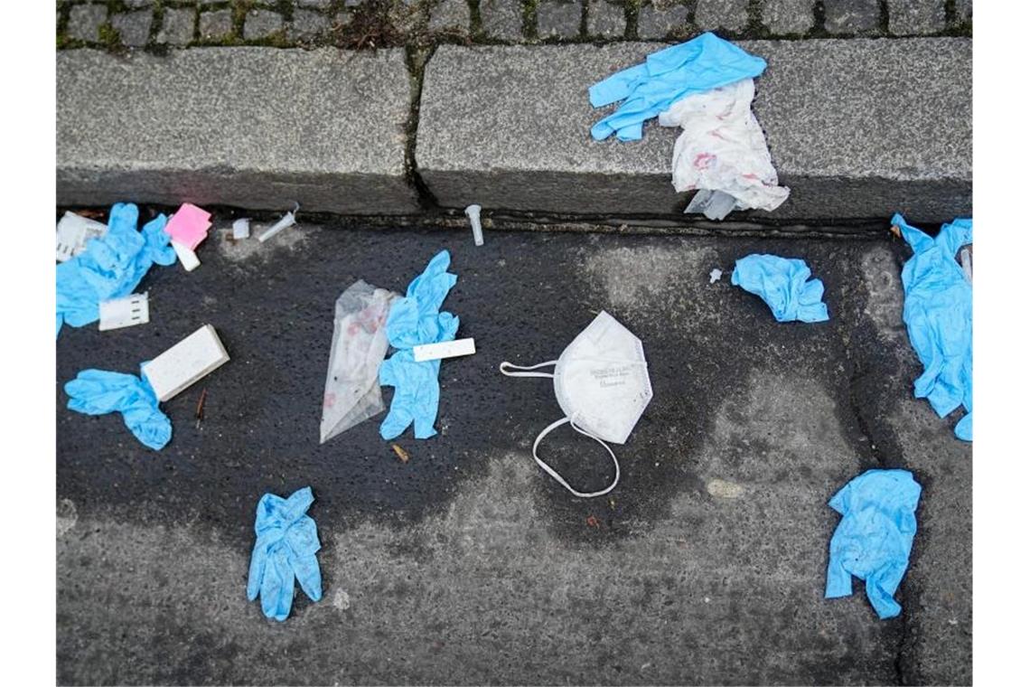 WHO: Pandemie führt zu riesigem Berg an Medizinmüll Einmalhandschuhe, FFP2-Maske und benutzte Corona-Antigen-Testkits liegen auf der Straße vor einem Corona-Testzentrum. Foto: Kay Nietfeld/dpa