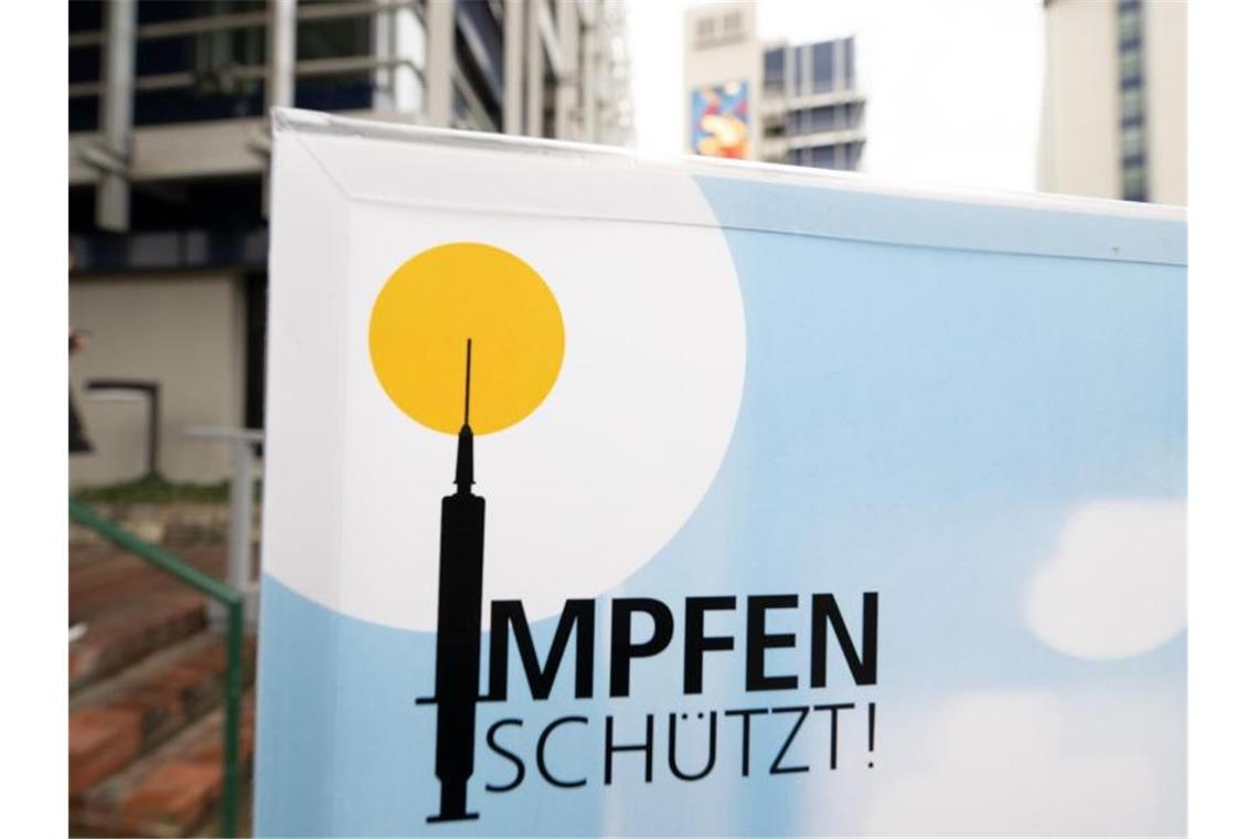 Ein Plakat mit der Aufschrift „Impfen schützt“ steht vor einem Impfzentrum in Stuttgart. Foto: Bernd Weißbrod/dpa/Symbolbild