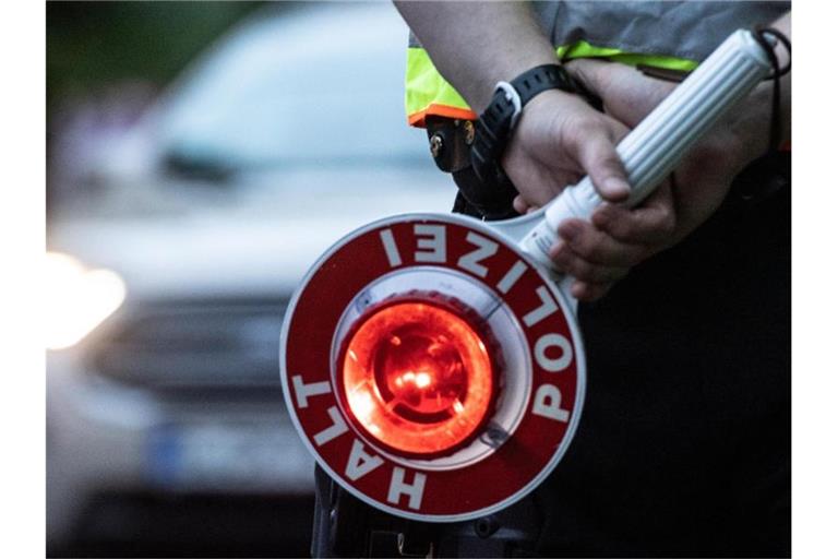 Ein Polizist hält bei einer Verkehrskontrolle eine Winkerkelle in der Hand. Foto: Paul Zinken/dpa/ZB/Symbolbild