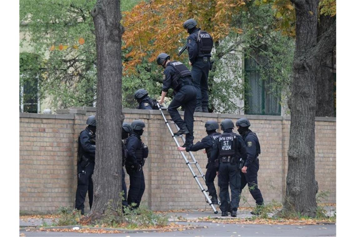 Rechtsextremist wollte Massaker in Halle anrichten Einsatz in Halle: Polizisten mit Schutzhelmen übersteigen eine Mauer. Foto: Sebastian Willnow/dpa-Zentralbild/dpa