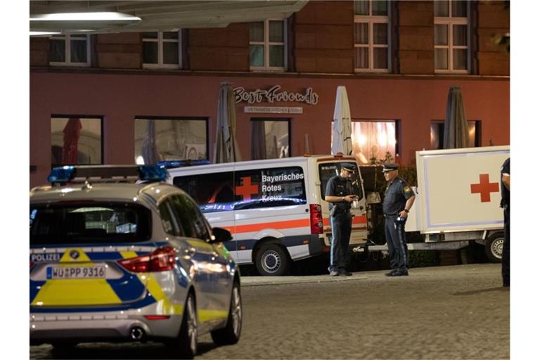 Einsatzfahrzeuge stehen nahe des Tatorts auf dem Barbarossaplatz in der Innenstadt von Würzburg. Foto: Daniel Karmann/dpa