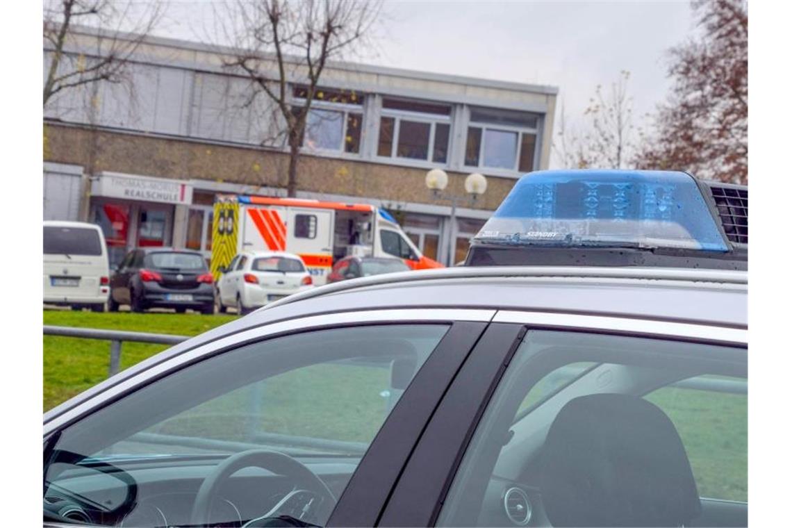 Einsatzfahrzeuge von Polizei und Rettungsdiensten stehen vor einer Schule in Östringen, an der ein 13-Jähriger einen Mitschüler attackierte. Foto: Julian Bucher/Einsatzreport 24/dpa