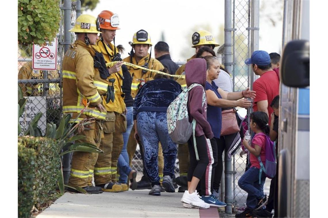 US-Flugzeug lässt Treibstoff über Grundschule ab Einsatzkärfte vor Ort kümmern sich um Eltern und Kinder. Das Flugzeug musste den Treibstoff, um das Gewicht bei der Landung zu reduzieren. Foto: Scott Varley/The Orange County Register/AP/dpa