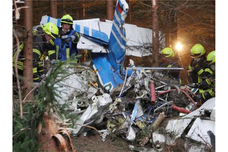 Einsatzkräfte arbeiten am Wrack eines Kleinflugzeugs, das in einen Wald in Wilnsdorf gestürzt ist. Foto: Kay-Helge Hercher/dpa