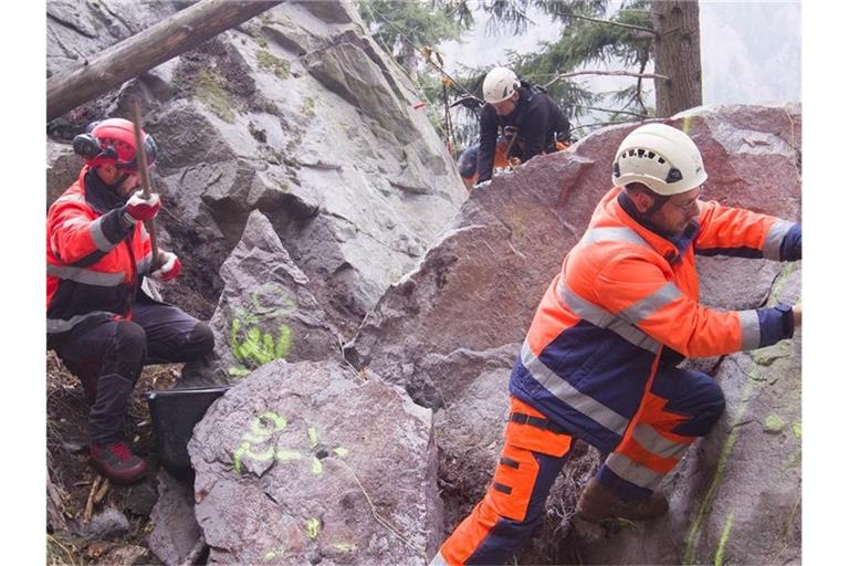 Einsatzkräfte bereiten die Sprengung eines großen Felsbrockens im Höllental vor. Foto: Thomas Reichelt/dpa