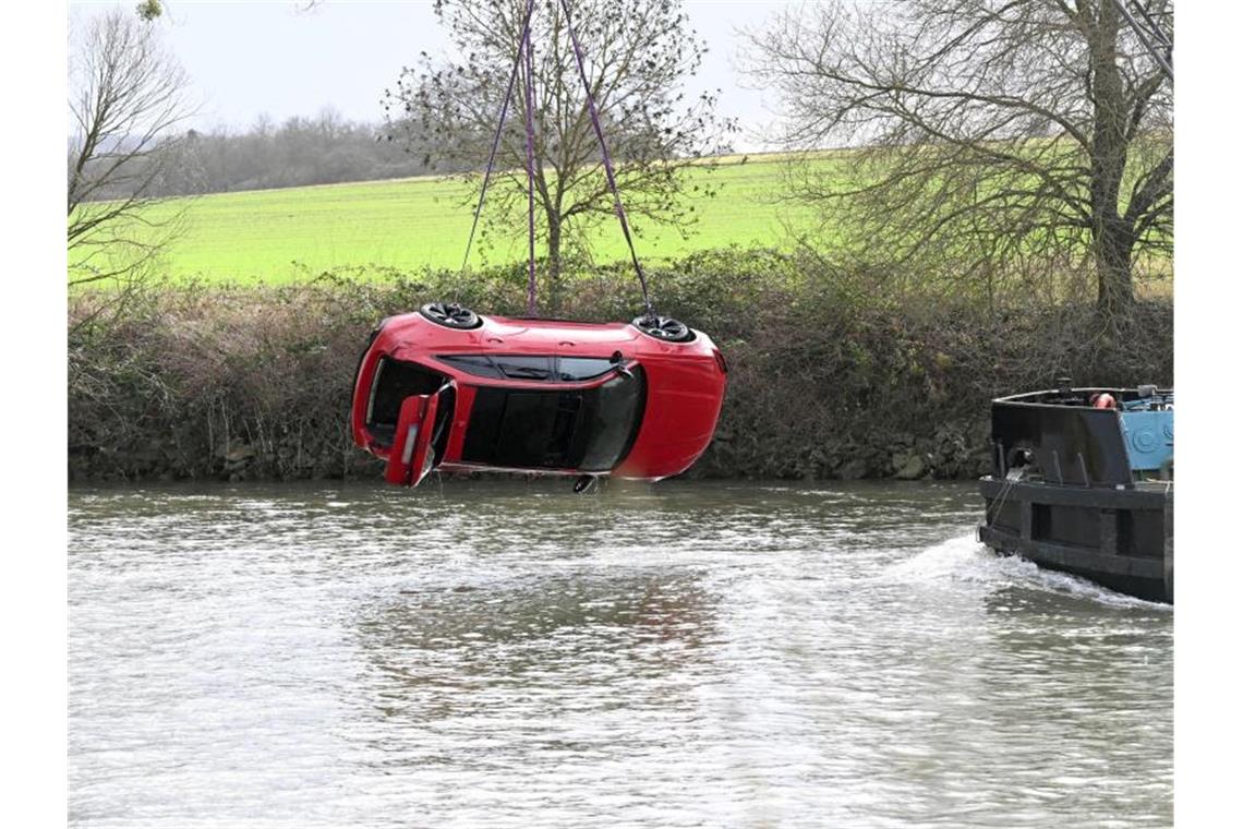 Versunkenes Luxusauto erfolgreich aus dem Neckar gezogen Einsatzkräfte bergen das Auto aus dem Fluss. Foto: Bernd Weißbrod/dpa