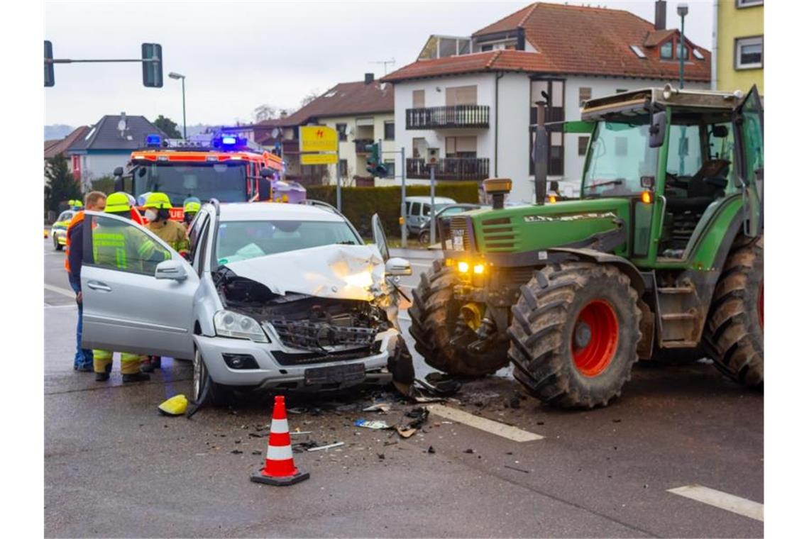 Einsatzkräfte der Feuerwehr bei dem Traktor und dem Auto nach deren Kollision. Foto: Markus Rott/Einsatz-Report24/dpa