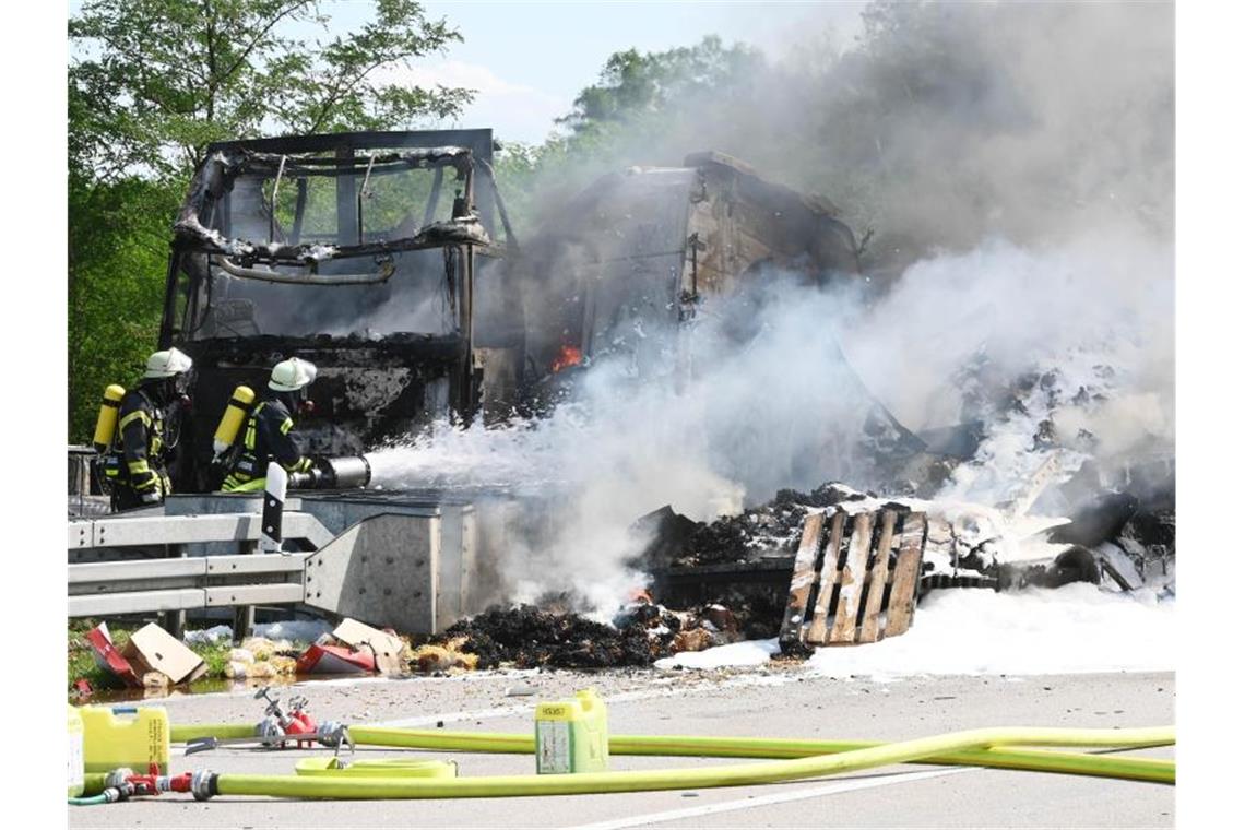 Einsatzkräfte der Feuerwehr löschen auf Autobahn 5 bei Karlsruhe Fahrzeuge. Foto: Uli Deck/Archivbild