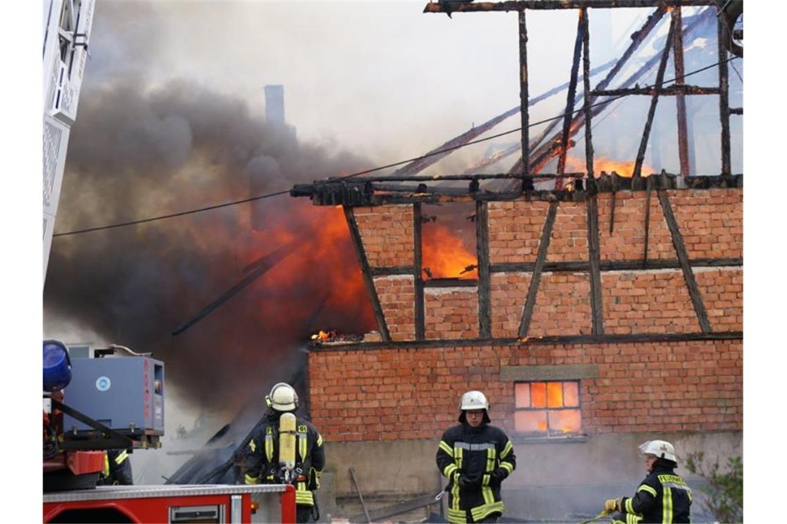 Einsatzkräfte der Feuerwehr löschen das Feuer auf dem Hof in der Gemeinde Urbach. Foto: Kohls/SDMG/dpa