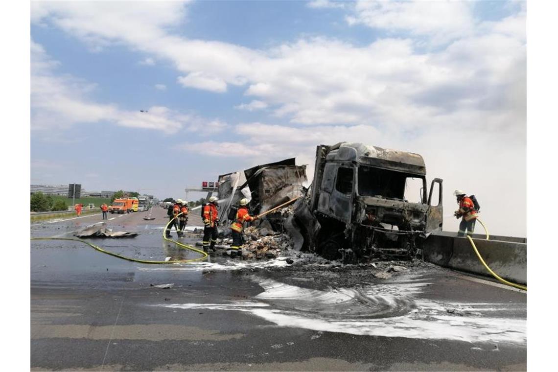Einsatzkräfte der Feuerwehr löschen einen Brand an einem Lastwagen auf der Autobahn A81. Foto: Andreas Rosar/dpa