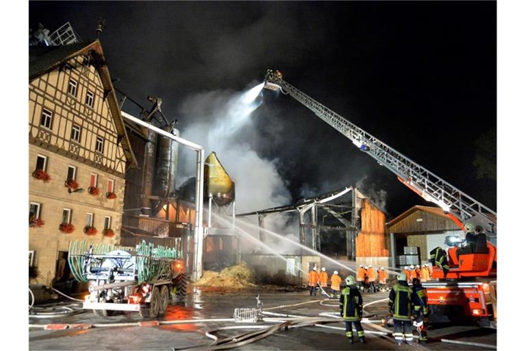 Einsatzkräfte der Feuerwehr löschen einen brennenden Mühlenbetrieb. Foto: Sven Friebe/dpa