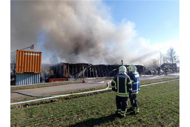 Einsatzkräfte der Feuerwehr löschen einen Großbrand in einer Lagerhalle in Reutlingen. Foto: Kullen/dpa