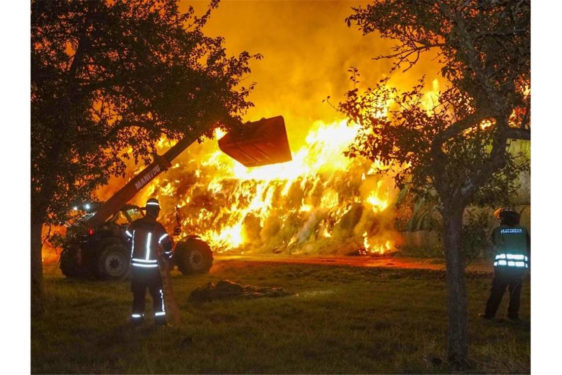 Zehn Jahre Haft: Feuerwehrmann als Brandstifter verurteilt Einsatzkräfte der Feuerwehr löschen im Oktober 2020 einen Brand von rund 400 Strohballen in Gundelsheim. Foto: Franziska Hessenauer/dpa