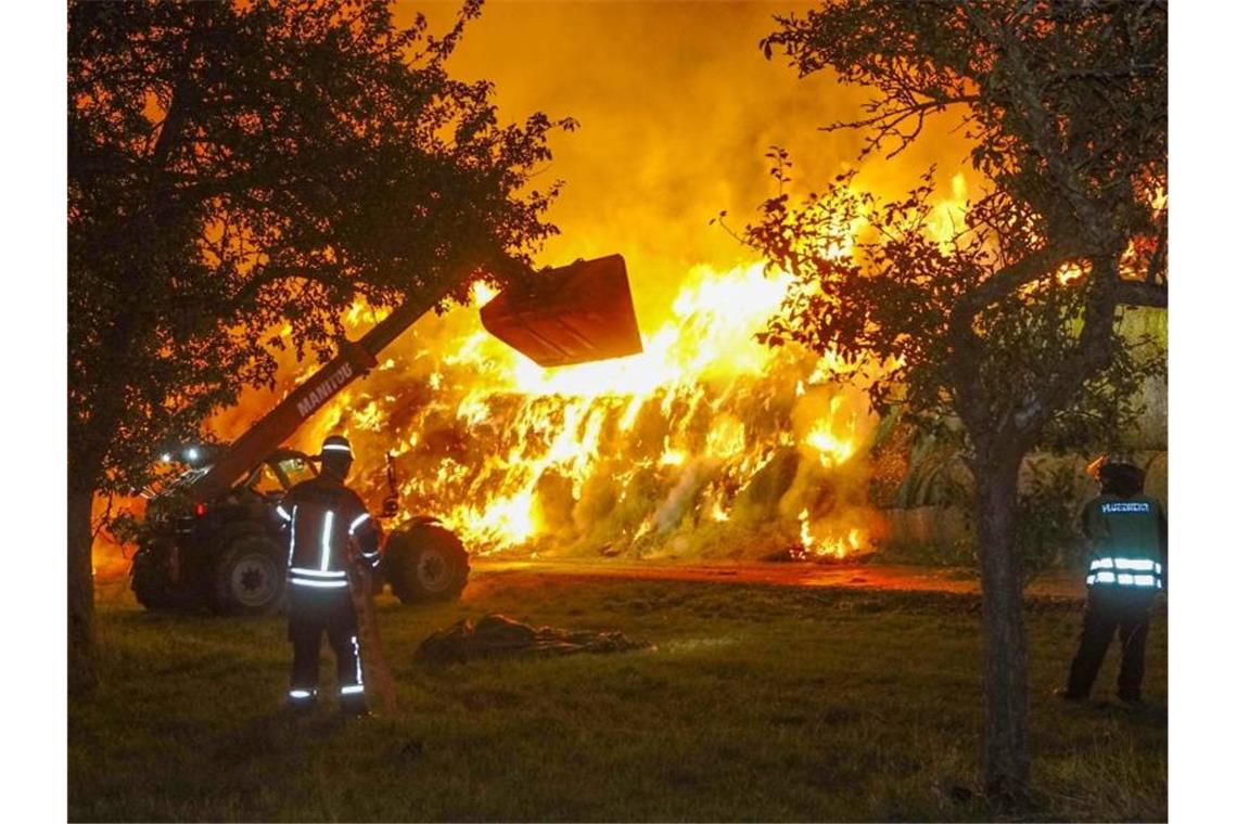 Einsatzkräfte der Feuerwehr löschen im Oktober 2020 einen Brand von rund 400 Strohballen in Gundelsheim. Foto: Franziska Hessenauer/dpa