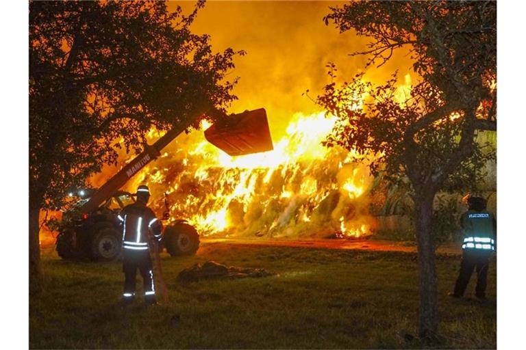 Einsatzkräfte der Feuerwehr löschen im Oktober 2020 einen Brand von rund 400 Strohballen in Gundelsheim. Foto: Franziska Hessenauer/dpa