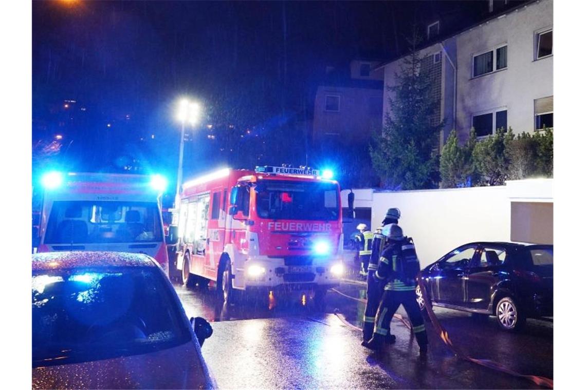 Wohnungsbrand in Stuttgart: 89-Jährige Frau tot aufgefunden Einsatzkräfte der Feuerwehr, Rettungskräfte und Polizei stehen vor dem Mehrfamilienhaus. Foto: Andreas Rosar/dpa