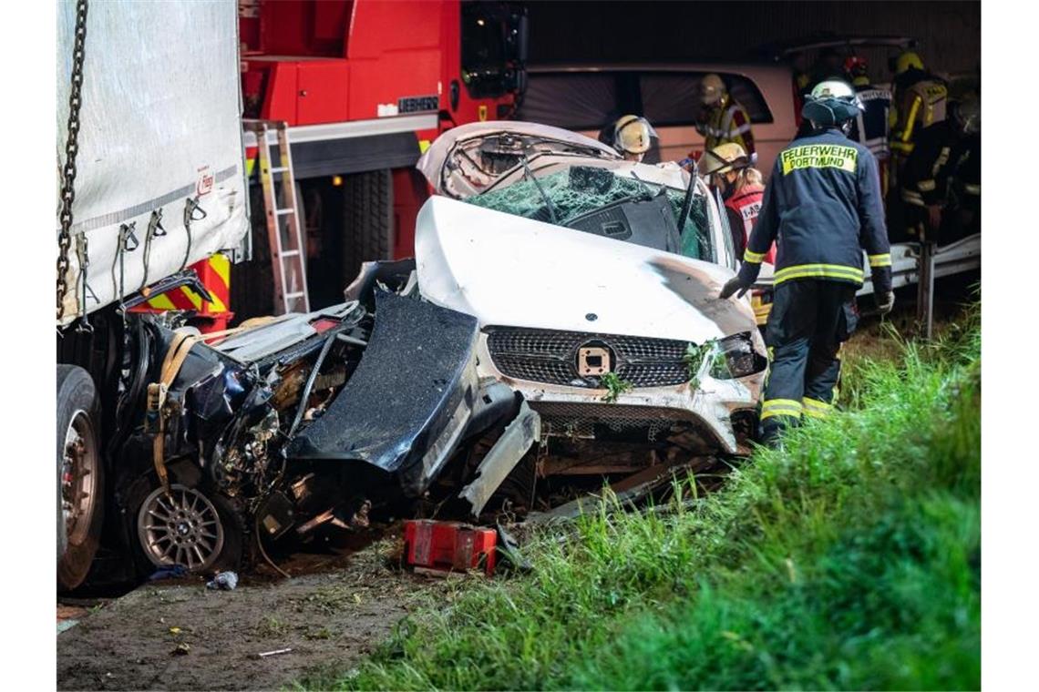 Einsatzkräfte der Feuerwehr stehen auf der A2 neben völlig zerstörten Fahrzeugen. Foto: Marcel Kusch/dpa