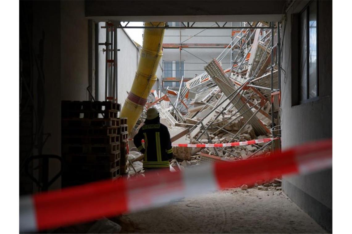 Vermisster Bauarbeiter tot in Trümmern entdeckt Einsatzkräfte der Feuerwehr stehen in einer Hauseinfahrt. Foto: Henning Kaiser/dpa