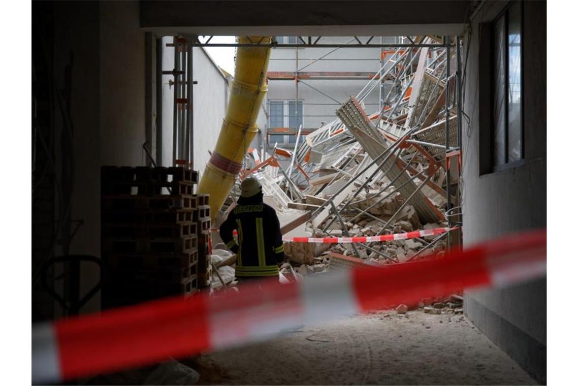 Einsatzkräfte der Feuerwehr stehen in einer Hauseinfahrt. Foto: Henning Kaiser/dpa