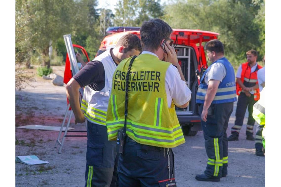 Ultraleichtflugzeug stürzt in Wald: Zwei Tote Einsatzkräfte der Feuerwehr stehen mit Fahrzeugen auf einem Waldparkplatz. Foto: Aaron Klewer/Einsatz-Report24/dpa