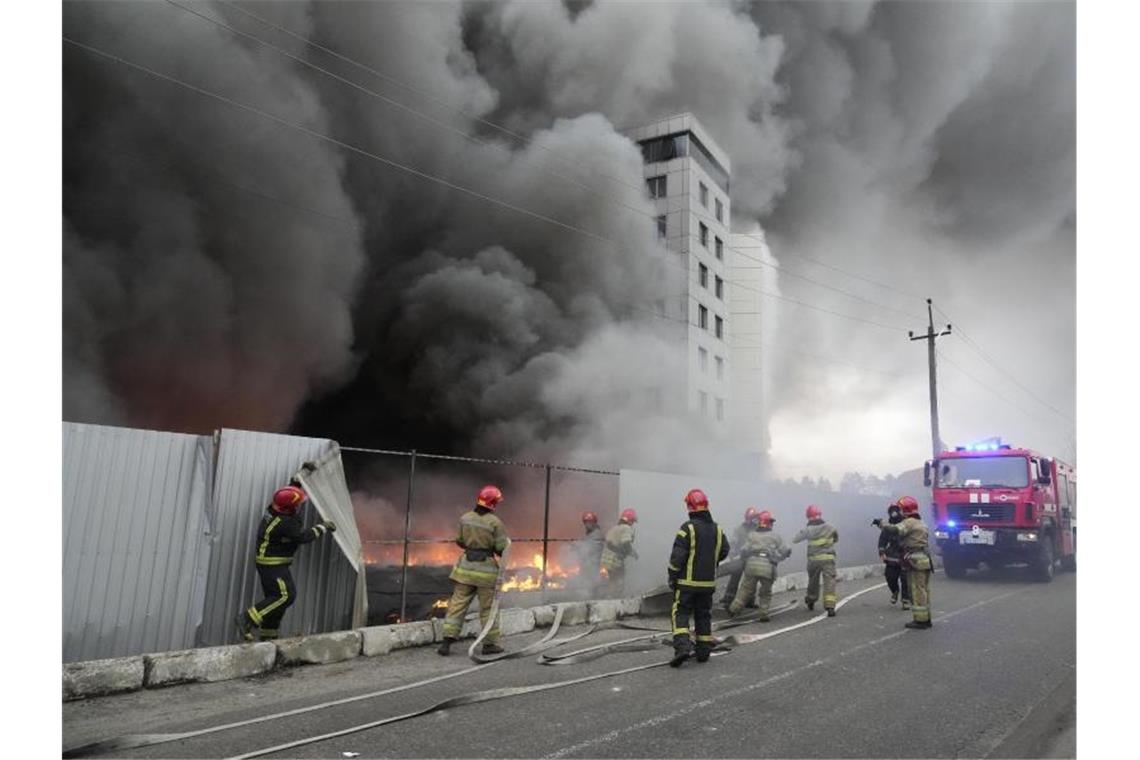 Humanitäre Hilfe für die Ukraine - Lebensmittel aus Japan Einsatzkräfte der Feuerwehr stehen vor einem Logistikzentrum, das nach Beschuss in Brand geraten ist. Foto: Efrem Lukatsky/AP/dpa