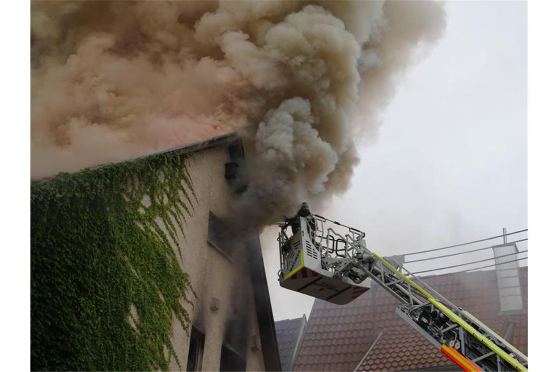 Einsatzkräfte der Feuerwehr versuchen, den Brand in einem Wohnhaus im Kreis Esslingen zu löschen. Foto: Kohls/SDMG/dpa