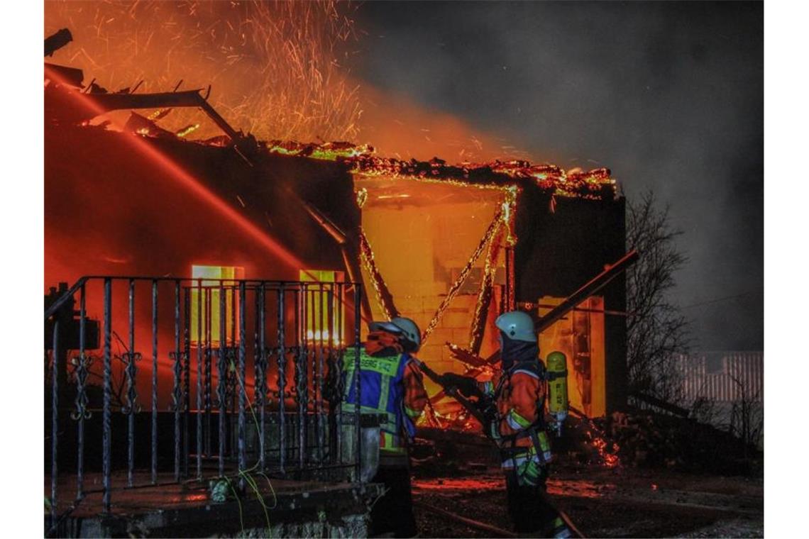 Einsatzkräfte der Feuerwehr versuchen eine brennende Scheune in Vellberg zu löschen. Foto: Anton Scheurer/Ostalb Network/dpa