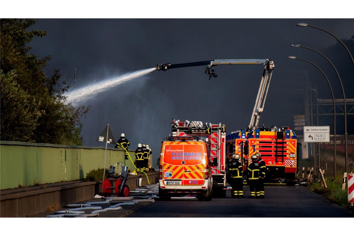Einsatzkräfte der Feuerwehr versuchen, einen Brand in einem Industriegebiet im Hamburger Hafen zu löschen.