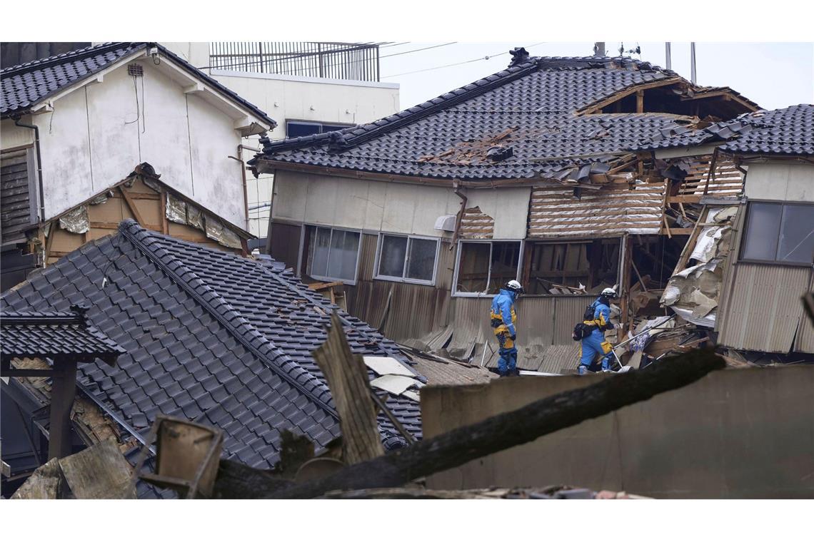 Einsatzkräfte der Polizei durchsuchen nach dem Erdbeben beschädigte Häuser in Wajima.
