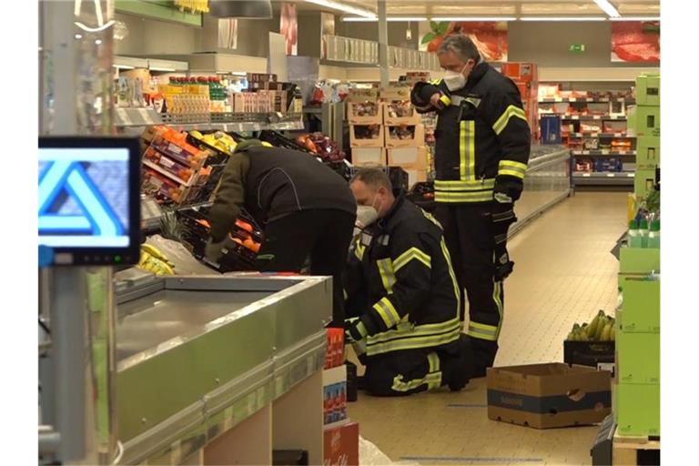 Einsatzkräfte der Polizei, Feuerwehr und ein Spinnenexperte suchen in Obst- und Gemüseregalen nach der Spinne. Foto: Nord-West-Media/Nord-West-Media /dpa