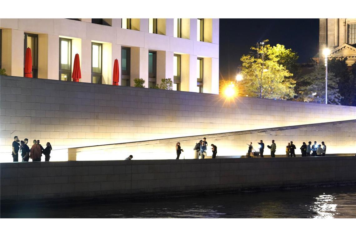 Einsatzkräfte der Polizei stehen vor dem Humboldt-Forum am Ufer der Spree.
