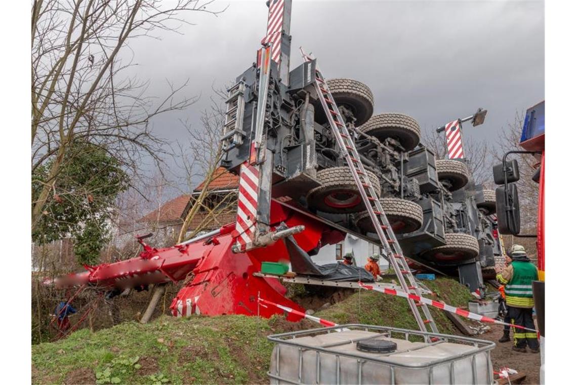 Einsatzkräfte der Rettungsdienste arbeiten an einer Unfallstelle, an der ein Autokran umgestürzt ist. Foto: Aaron Klewer/dpa