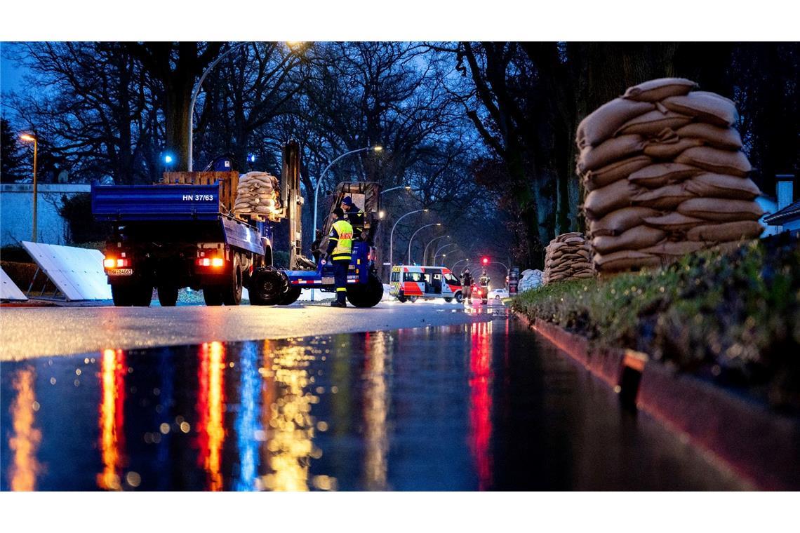 Einsatzkräfte des Technischen Hilfswerks (THW) laden in Oldenburg zahlreiche Sandsäcke ab. Ein mobiler Deich soll die Wohngebiete im Stadtteil Bümmerstede vor einem drohenden Hochwasser schützen.