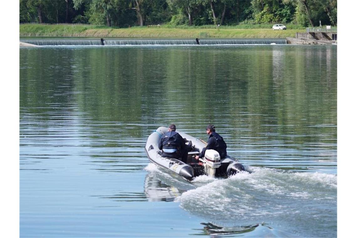 Einsatzkräfte fahren mit einem Schlauchboot nahe der Stelle auf dem Rhein, an der ein Schlauchboot verunglückt ist. Foto: Benedikt Spether