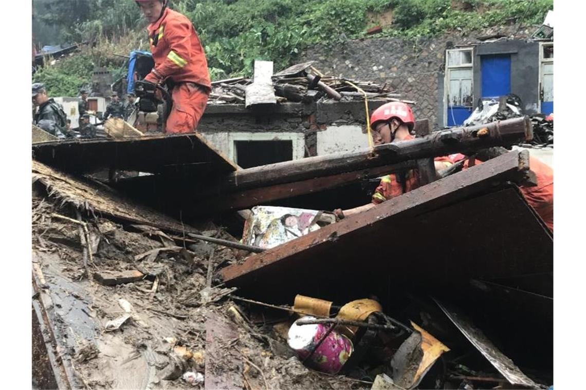 Taifun wütet in China: Mindestens 22 Tote nach Erdrutsch Einsatzkräfte sind in den Trümmern eines eingestürzten Gebäudes im Einsatz. Foto: Zhao Yong/XinHua
