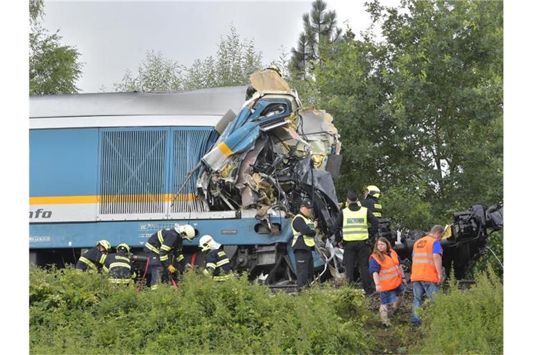 Einsatzkräfte stehen an einem zerstörten Waggon. Foto: Chaloupka Miroslav/CTK/dpa
