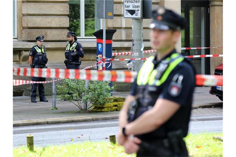 Einsatzkräfte stehen an einer Polizeiabsperrung auf dem Gorch-Fock-Wall in Hamburg. Foto: Bodo Marks/dpa