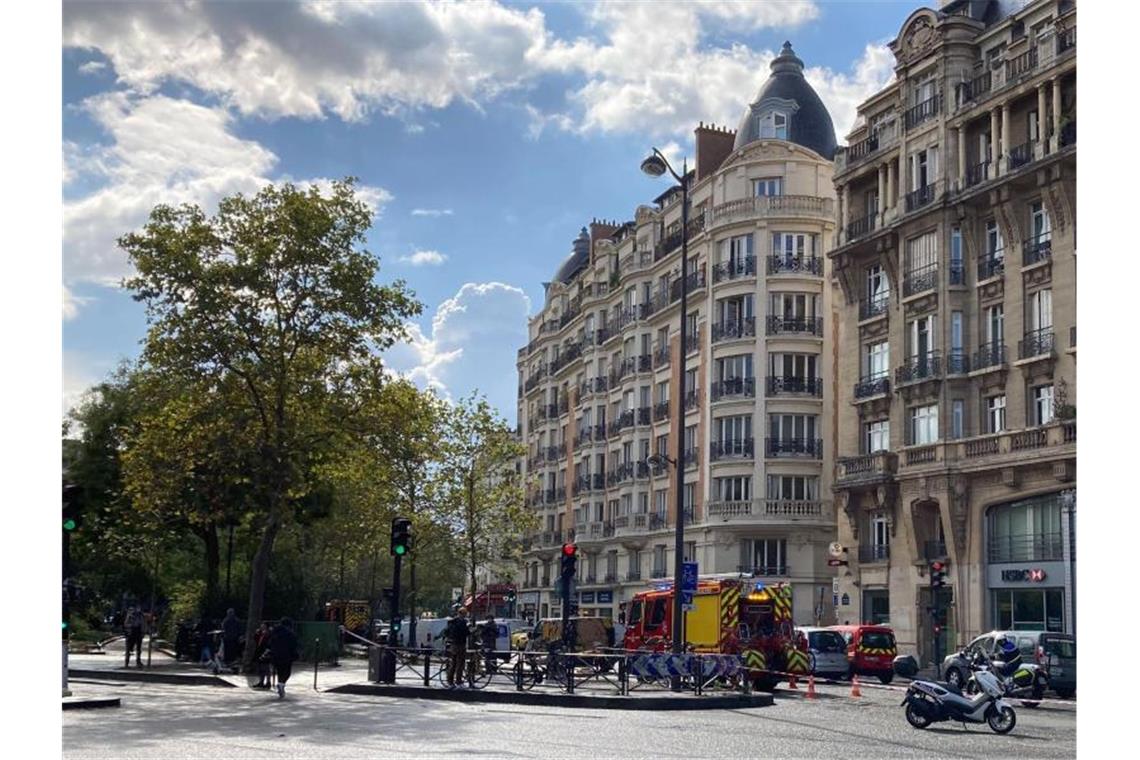 Einsatzkräfte stehen in einer abgesperrten Straße in Paris. Foto: Pol O'Gradaigh/dpa