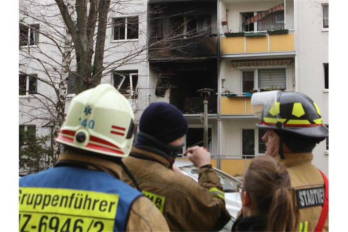 Einsatzkräfte stehen nach der Explosion vor dem Mehrfamilienhaus. Foto: Matthias Bein/dpa-Zentralbild/dpa