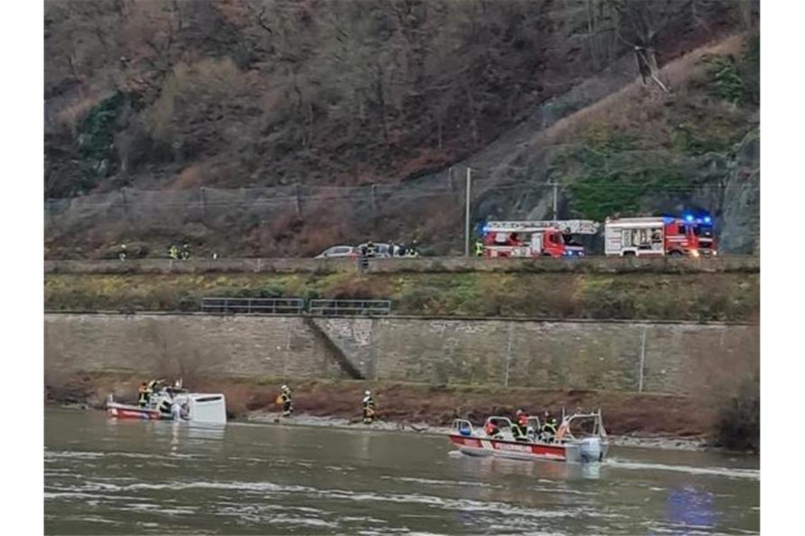 Einsatzkräfte von Feuerwehr und Wasserschutzpolizei kümmern sich um das im Rhein treibende Wohnmobil. Foto: -/Wasserschutzpolizei/dpa