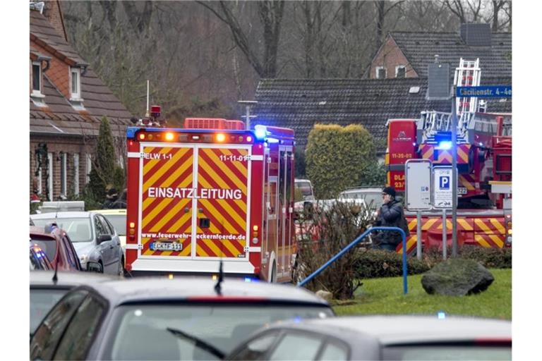 Einsatzkräfte von Polizei und Feuerwehr stehen neben einem Haus in Eckernförde, in dem sich ein junger Mann beim Herstellen von Böllern schwer verletzt hat. Foto: Axel Heimken/dpa