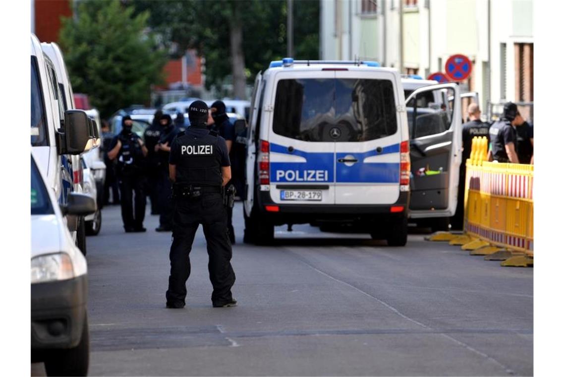 Einsatzkräfte von Polizei und Zoll stehen auf der Straße. Foto: Hendrik Schmidt/dpa-Zentralbild/dpa