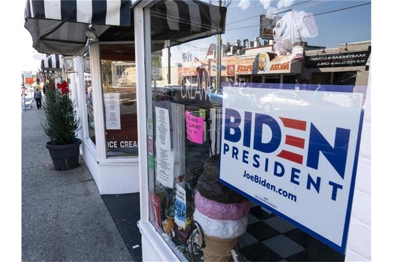 Ein Schild für den designierten Präsidenten der USA hängt in einem Schaufenster. Joe Biden bereitet jetzt schon Erlasse vor, um am ersten Tag seiner Amtszeit diverse politische Entscheidungen von Donald Trump rückgängig zu machen. Foto: Alex Brandon/AP/dpa