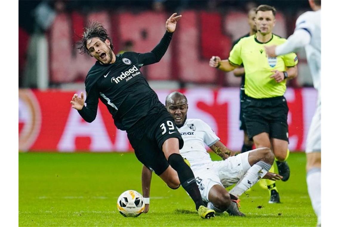 Trotz Heimpleite: Frankfurt zieht in K.o.-Runde ein Eintrachts Goncalo Paciencia (l) wird unsanft von Ali Al Musrati vom Ball getrennt. Foto: Uwe Anspach/dpa