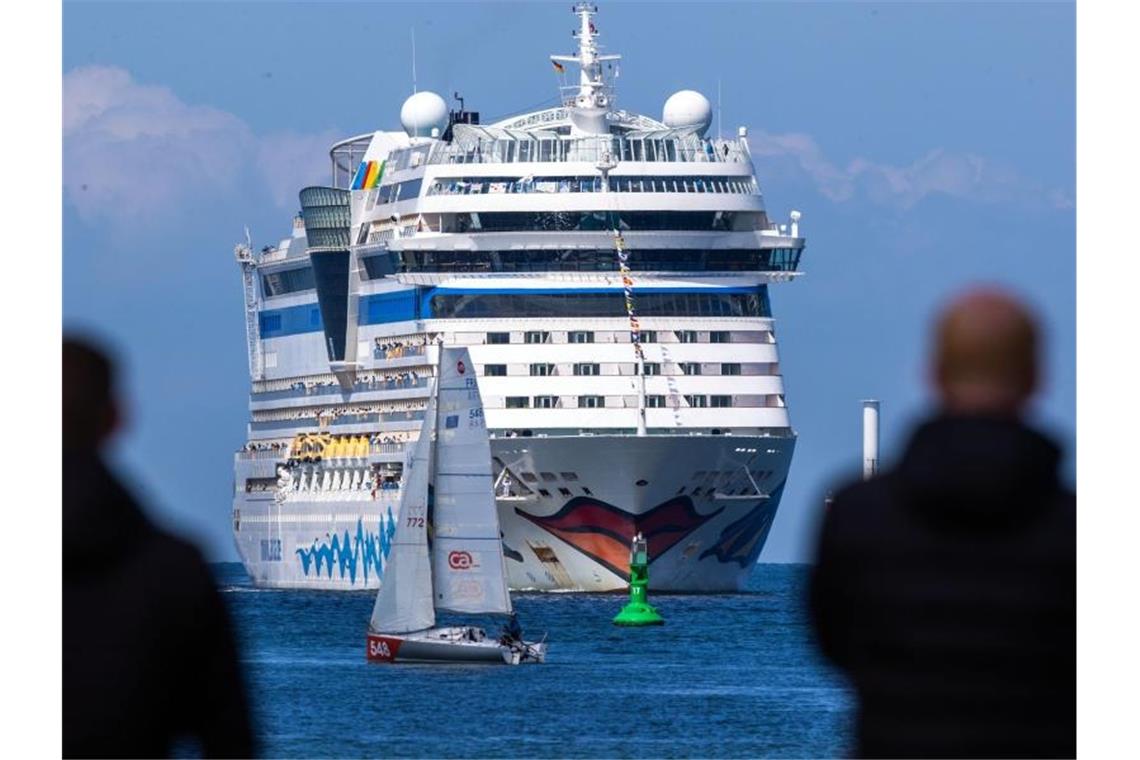 Kreuzfahrt-Branche startet Saison in Deutschland Einwohner der Hansestadt Rostock und Kreuzfahrtfans begrüßen das Kreuzfahrtschiff „Aidasol“ beim Einlaufen in den Hafen. Foto: Jens Büttner/dpa-Zentralbild/dpa