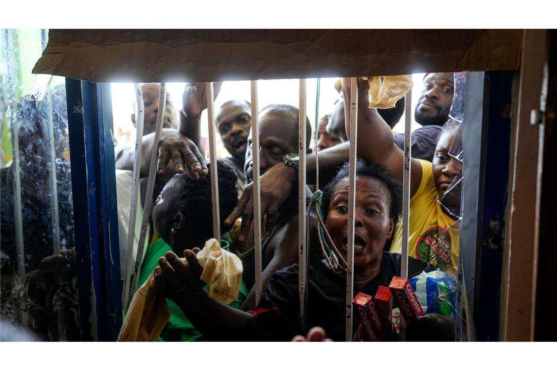 Einwohner drängen sich nach dem Durchzug des Hurrikans "Melissa" vor einen geschlossenen Supermarkt in Black River auf Jamaika und bitten um Vorräte.