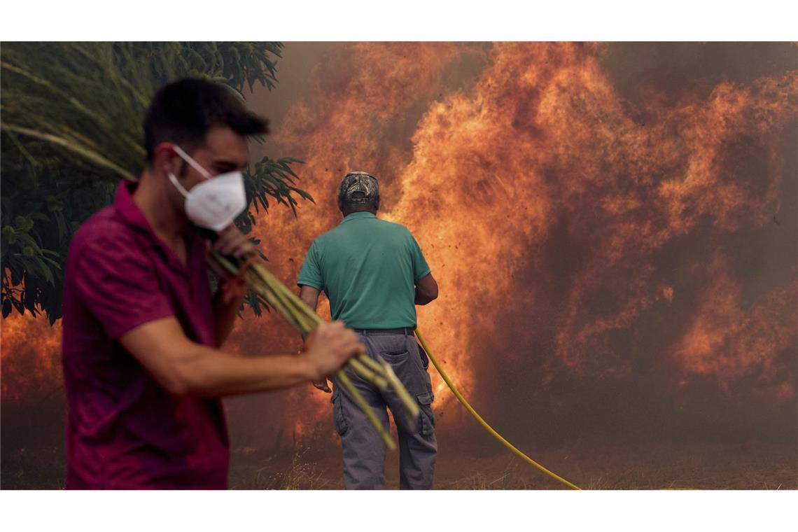 Einwohner kämpfen gegen ein Feuer, das sich auf das Dorf Rebordondo in der Nähe von Ourense im Nordwesten Spaniens ausbreitet.