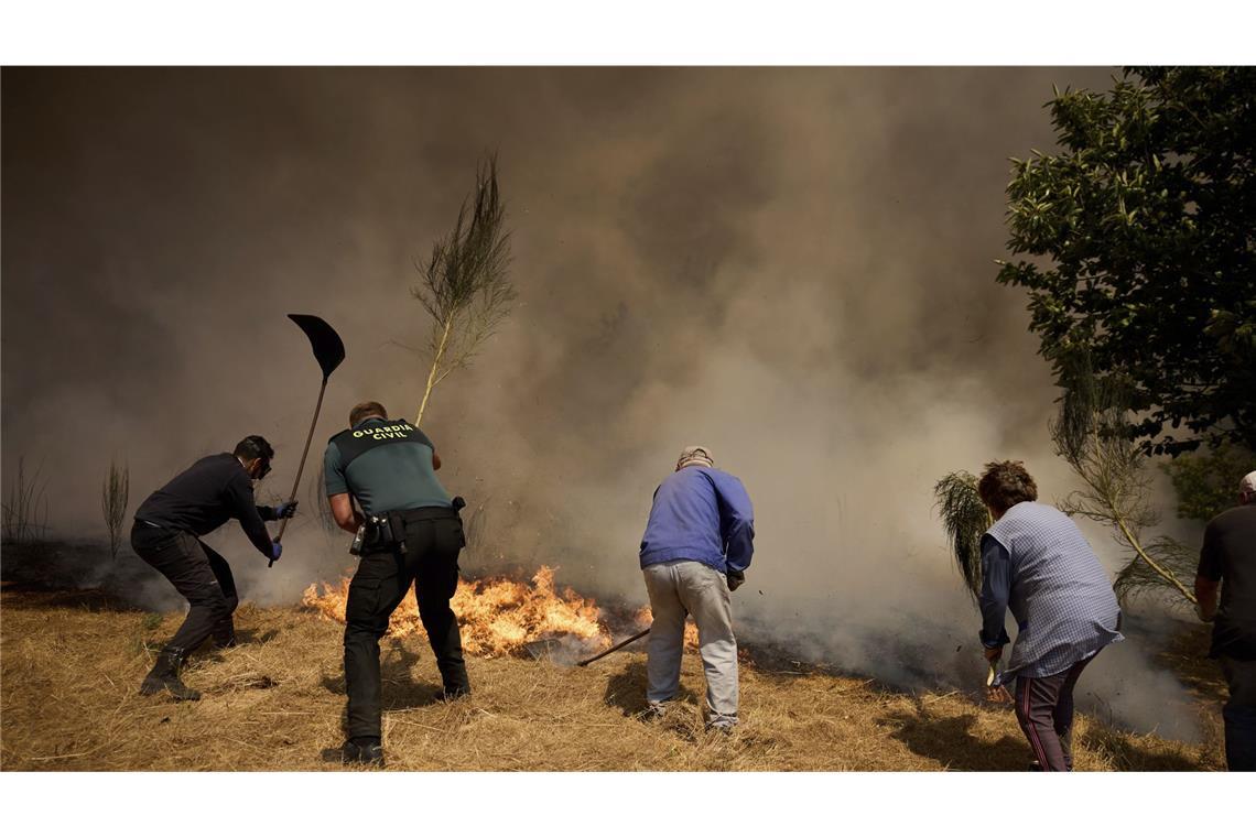Einwohner kämpfen gegen ein Feuer, das sich auf das Dorf Rebordondo in der Nähe von Ourense im Nordwesten Spaniens ausbreitet.
